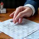 Hands exchanging design sketches and plant samples, representing client consultation.